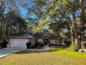 Single-story home with a pink garage door and stone accents at 9221 Sw 193Rd Cir, Dunnellon, FL 34432