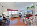 Bright living room with hardwood floors, comfortable seating, and a view into the kitchen at 9688 Sw 45Th Ave, Ocala, FL 34476