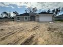 New construction home showcasing a modern design, gray exterior paint, and an attached two-car garage at 10927 Sw 41St Ave, Ocala, FL 34476