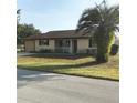 Single-story home with a palm tree and well-maintained lawn at 10973 Sw 86Th Ct, Ocala, FL 34481