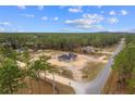 An aerial view shows the home on a large lot surrounded by trees and another home down the street at 11910 Sw 43Rd Street Road, Ocala, FL 34481