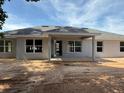 Rear of the home featuring a covered patio and several large windows offering lots of natural light at 13 Nw 45Th Loop, Ocala, FL 34475
