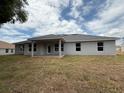 The rear exterior shows a covered patio and a spacious lawn and yard at 13 Nw 45Th Loop, Ocala, FL 34475