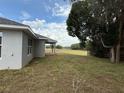 View of the backyard with ample green space and mature trees at 13 Nw 45Th Loop, Ocala, FL 34475