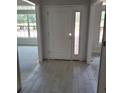 Bright entryway with white door and light-colored tile flooring at 13 Nw 45Th Loop, Ocala, FL 34475