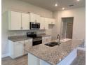 Well-lit kitchen featuring stainless steel appliances, granite countertops, and white cabinetry at 13 Nw 45Th Loop, Ocala, FL 34475