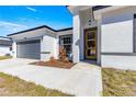 Modern front entrance with gray walkway and yellow door at 15413 Sw 65Th Terrace Rd, Ocala, FL 34473