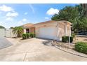 Exterior view of a single-story house with a driveway, lamp post, and landscaped yard at 1801 Marquez Loop, Lady Lake, FL 32159