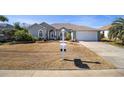 Single-story house with a two-car garage and mature landscaping at 2330 Nw 59Th Ave, Ocala, FL 34482