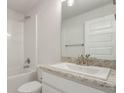 Bright bathroom with a shower-tub combo, a brushed nickel faucet, and granite countertops at 3192 Ne 46Th Ave, Ocala, FL 34470