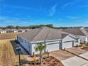 Rear exterior view of a new home showcasing a two-car garage and landscaping at 5365 Nw 46Th Lane Rd, Ocala, FL 34482