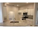 Modern kitchen featuring stainless steel appliances, granite countertops, and ample cabinet space at 7 Nw 45Th Loop, Ocala, FL 34470