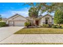 Single story house with three car garage, mature landscaping, and palm trees at 7316 Sw 94Th Ct, Ocala, FL 34481