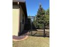 Side yard view showcasing a black metal fence and a gate, with landscaping at 9143 Sw 70Th Loop, Ocala, FL 34481