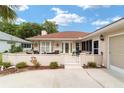 Front view of house with white walls, red tile roof and a gated patio at 11159 Sw 68Th Ct, Ocala, FL 34476