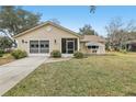 Tan house with double garage and driveway at 1314 Noble Ct, Leesburg, FL 34788