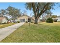 Tan house with driveway and landscaping at 1314 Noble Ct, Leesburg, FL 34788