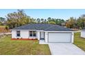 Attractive single-story home featuring gray roof, light gray trim, white exterior, and a two-car garage at 15294 Sw 27 Ln, Ocala, FL 34481