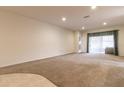 Spacious living room with neutral carpeting and access to sliding doors at 16205 Sw 12Th Ter, Ocala, FL 34473