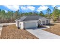 New construction home exterior with light beige siding and gray roof at 8786 Sw 127 Ave, Dunnellon, FL 34432