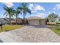 Single-story home boasting a brick-paved driveway, well-maintained landscaping, and a convenient two-car garage at 9651 Se 137Th Street Rd, Summerfield, FL 34491