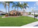 Beautiful single-story home showcasing meticulously landscaped grounds and elegant curb appeal with soaring palms at 9651 Se 137Th Street Rd, Summerfield, FL 34491