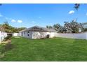 Large backyard with a grassy area and white vinyl fence at 1302 Ne 22Nd Ave, Ocala, FL 34470