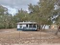 White single-story home with a dark-colored deck and fenced yard at 14497 Ne 189Th Pl, Fort Mc Coy, FL 32134