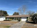 Ranch style home with a green exterior, attached garage, and landscaping at 15083 Sw 43Rd Terrace Rd, Ocala, FL 34473