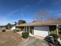Green house with white garage door and mature trees in the yard at 15083 Sw 43Rd Terrace Rd, Ocala, FL 34473