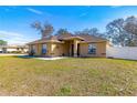 Tan one-story house with a brown door and nicely landscaped yard at 15391 Se 90Th Ct, Summerfield, FL 34491