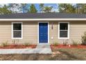 Inviting front entrance features a bright blue door flanked by white-trimmed windows at 15982 Sw 30 Ln, Ocala, FL 34481
