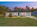 Newly built home at dusk showcasing gray siding and teal front door at 24025 Nw Foxglove Lane, Dunnellon, FL 34431