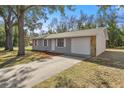 View of the renovated single-story home with a new driveway and landscaping at 26 Spring Cir, Ocala, FL 34472