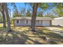 View of the renovated house with a new driveway and fresh mulch at 26 Spring Cir, Ocala, FL 34472