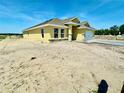 A stunning single-story house with a two-car garage and desert landscaping against a clear blue sky at 3212 Ne 46Th Ave, Ocala, FL 34470