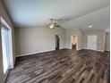 Spacious living room with dark vinyl wood flooring, a ceiling fan, and an open layout to other areas at 6414 Sw 67Th Pl, Ocala, FL 34476