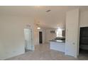 Open kitchen with grey cabinets, tile floors, and island at 67 Nw Sparrow Rd, Dunnellon, FL 34431