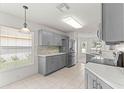 Bright kitchen with stainless steel appliances, gray cabinets, and tile flooring at 9014 Sw 96Th Ter, Ocala, FL 34481