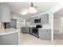Modern kitchen with gray cabinets, stainless steel appliances, and stylish backsplash at 9014 Sw 96Th Ter, Ocala, FL 34481