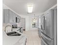Bright kitchen with stainless steel appliances, gray cabinets, and tile flooring at 9014 Sw 96Th Ter, Ocala, FL 34481