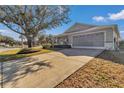 Charming home featuring a well-maintained lawn, long driveway, covered porch, and an attached garage at 9708 Sw 97Th St, Ocala, FL 34481