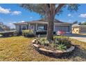 Charming home with a large tree and brick-lined flower bed in the front yard and attached garage at 9708 Sw 97Th St, Ocala, FL 34481