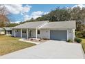 Well-manicured single-story home featuring an attached garage and a tidy front lawn with a charming front entrance at 1517 New Abbey Ave, Leesburg, FL 34788