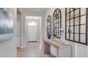 Bright foyer featuring tile floors, console table with decorative mirrors, and direct view of front door at 4038 Nw 48Th Terrace Rd, Ocala, FL 34482