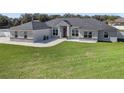 Attractive single-story home showcasing a neatly kept lawn and a stylish brick and gray facade at 6215 Se 13Th St, Ocala, FL 34472