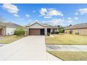 Front view of a one-story house with a brown garage door at 7454 Sw 101St Ave, Ocala, FL 34481