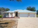 Charming front exterior with a three-car garage, metal roof, and well-maintained landscaping at 7688 Se 135Th St, Summerfield, FL 34491