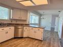 Bright kitchen featuring white cabinets, stainless steel dishwasher, and a view of the dining area at 8639 Sw 116Th Lane Rd, Ocala, FL 34481