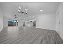 Open living room with gray vinyl flooring and modern chandelier at 9731 Bahia Rd, Ocala, FL 34472